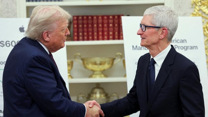 U.S. President Donald Trump and Apple CEO Tim Cook shake hands on the day they present Apple's announcement of a $100 billion investment in U.S. manufacturing, in the Oval Office at the White House in Washington, D.C., U.S., August 6, 2025. REUTERS/Jonathan Ernst REFILE - QUALITY REPEAT