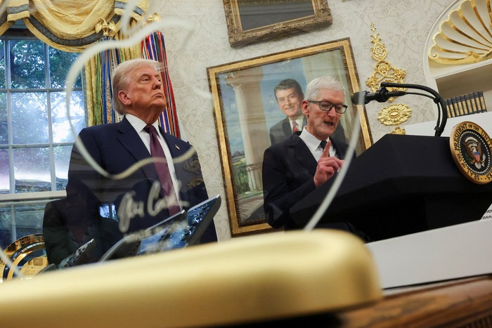 U.S. President Donald Trump and Apple CEO Tim Cook shake hands on the day they present Apples announcement of a $100 billion investment in U.S. manufacturing, in the Oval Office at the White House in Washington, D.C., U.S., August 6, 2025. REUTERS/Jonathan Ernst    REFILE - QUALITY REPEAT