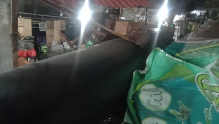 Pipa Besi muatan truk trailer terlepas lalu jatuh dari atas Tol Wiyoto Wiyono dan menimpa lapak pedagang di Pasar Cipluk, Penjaringan, Jakarta Utara, Rabu (6/8/2025) malam.