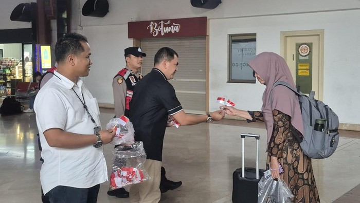 Polresta Bandara Soetta membagikan bendera merah putih kepada masyarakat di Terminal 2 Bandara Soetta.