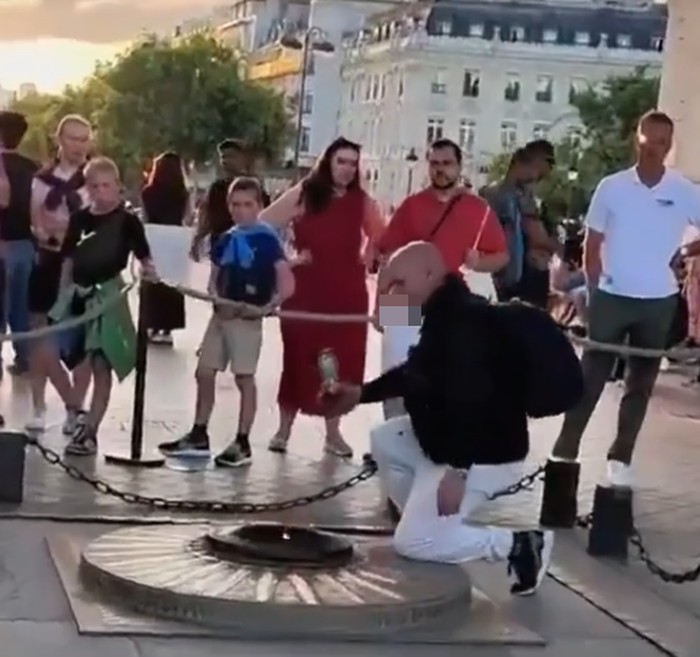 Pria nyalakan rokok di monumen api abadi di Arc de Triomphe Paris