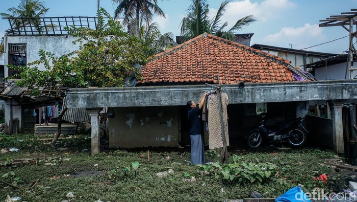 Sebuah rumah ambles di Bintara Jaya, Bekasi. Rumah itu seolah tenggelam bak dimakan tanah.