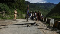 Warga berdiri di atas jalan yang rusak berat akibat longsor di Desa Bhatwadi, Distrik Uttarkashi, India, Rabu (7/8/2025). REUTERS/Francis Mascarenhas