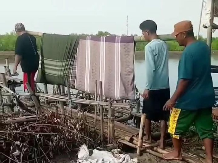 Warga menandu jenazah pakai sarung ke tempat pemakaman di Blok Empang Desa Eretan Wetan, Kecamatan Kandanghaur, Indramayu
