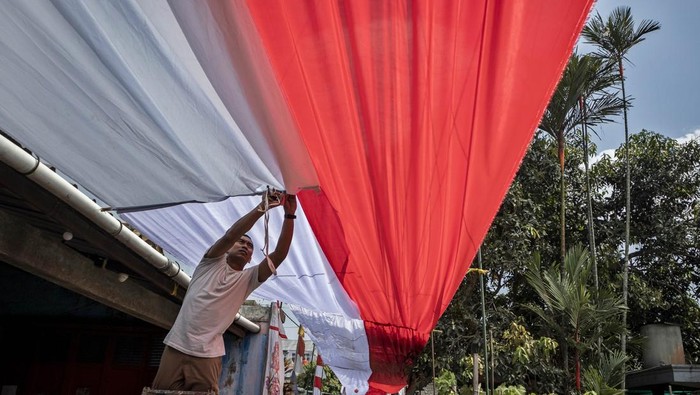 Warga memasang dekorasi kain merah putih di Kampung Rancabali, Padalarang, Kabupaten Bandung Barat, Jawa Barat, Kamis (7/8/2025). Warga setempat bergotong royong memasang kain merah putih sepanjang 100 meter dan membuat mural pahlawan nasional yang bertujuan untuk meningkatkan semangat nasionalisme serta menyemarakkan peringatan HUT Ke-80 Republik Indonesia. ANTARA FOTO/Abdan Syakura