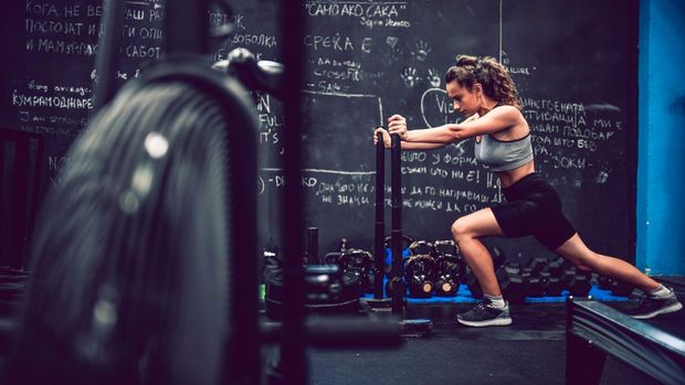 Female Pushing Weight Cart In Gym