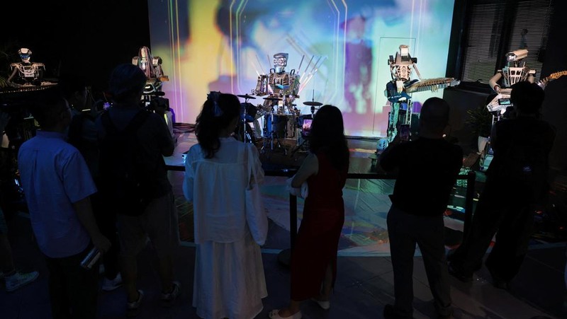 Media members work by a walking Tiangong humanoid robot during an organised media tour to Robot Mall, a store selling humanoid and other robots, in Beijing, China August 6, 2025. REUTERS/Florence Lo TPX IMAGES OF THE DAY