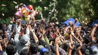 Warga berebut kue apem yang disebar pada acara Tradisi Sebaran Apem Yaqowiyu di Jatinom, Klaten, Jawa Tengah, Jumat (8/8/2025). Dalam tradisi budaya dan religi ini, warga berebut kue apem yang disebar dari atas panggung atau bangunan tinggi oleh panitia acara. ANTARA FOTO/Mohammad Ayudha