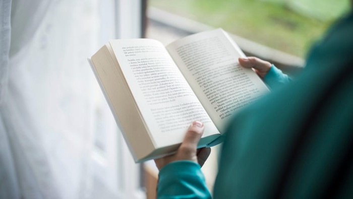 Orang sedang membaca buku novel