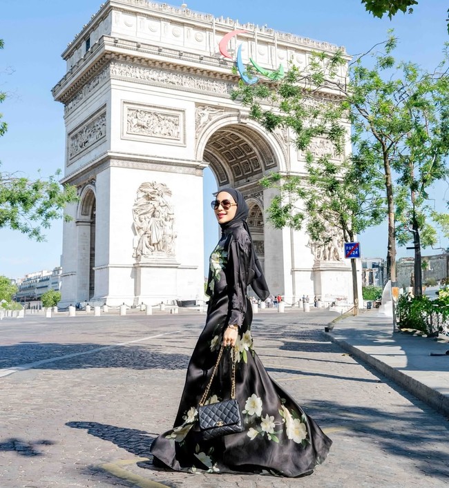 Gaun satin hitam dengan motif bunga menonjolkan aura anggun sekaligus glamor. Erin juga terlihat menenteng tas klasik Chanel. Foto: Instagram/@erintaulany