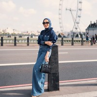 Bergaa denim on denim, Erin berpose dengan latar belakang landmark ikonik The London Eye di Inggris. Tas hitam dari kulit buaya melengkapi penampilannya. Foto: Instagram/@erintaulany