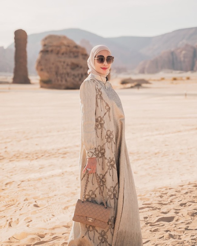 Erin Taulany, yang sedang menghadapi gugatan cerai dari suaminya, komedian Andre Taulany kerap tampil dengan gaya glamor. Salah satunya ketika liburan di Al Ula, Saudi Arabia, ibu tiga anak ini mengenakan gaun warna beige dibalut outer bercorak rantai dan pita. Tas Chanel klasik 11.12 melengkapi busananya. Foto: Instagram/@erintaulany