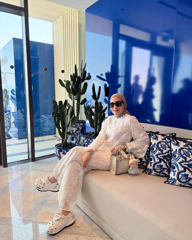 Tampil serba putih, Erin memadukan blouse dan celana lace dengan sepatu Crocs dan tas putih beraksen abu-abu. Dia juga mengikuti tren fashion terkini dengan boneka Labubu sebagai bag charm. Foto: Instagram/@erintaulany