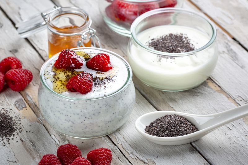 Ilustrasi yoghurt dan chia seed Poppy seed yoghurt dessert with honey and raspberries