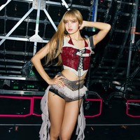 Kostum Lisa BLACKPINK satu ini sempat memicu kontroversi di tengah netizen Korea karena mengekspos bagian bokongnya dan dianggap terlalu terbuka. Penampilannya terdiri dari crop top beraksen vest merah dan micro pants abu-abu rancangan Grace Elwood. Foto: dok. Instagram @lalalalisa_m
