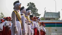 Layaknya sekolah lain, lagu kebangsaan bergema. Namun, pemandangan di sekitarnya berbeda: hanya beberapa meter dari bendera, menjulang tiang penyangga Tol Jakarta–Cikampek (Japek) II Selatan.