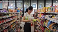 Sarwendah lalu menghampiri rak berisi berbagai macam makanan ringan. Ia pun terlihat sudah mengambil dua bungkus camilan berwarna kuning. Kira-kira camilan apa ya? Foto: Youtube / Sarwendah Official