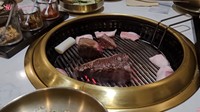 Tentu Sarwendah dan Giorgio Antonio tidak melewatkan kulineran cicip hidangan daging andalan di Korea. Sebelum disantap, pelayan membantu memanggang tiga potongan daging tebal di meja mereka. Foto: Youtube / Sarwendah Official