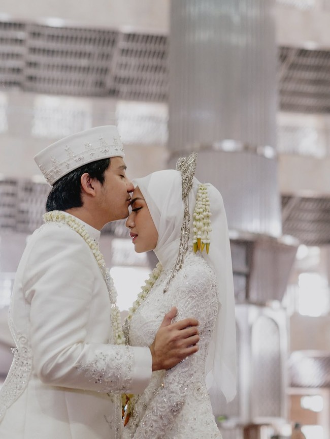 Dalam momen manis penuh cinta, Arbani terlihat mencium kening sang istri. Ia menuliskan, “Bismillah til Jannah🤍” sebagai keterangan foto Instagram. Foto: Instagram