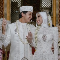 Keduanya tampil memukau dalam balutan busana pengantin berwarna putih dengan detail payet yang glamor, rancangan desainer Gugi Nugraha. Gaun Raissa berekor panjang, membuatnya terlihat anggun dalam balutan hijab. Foto: Instagram