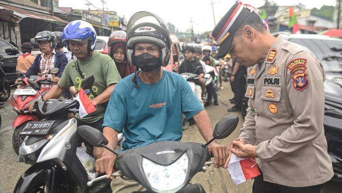 Polisi di Samarinda Bagikan 100 Bendera Merah Putih untuk Warga Polisi membagikan bendera Merah Putih kepada pengendara sepeda motor di Samarinda, Kalimantan Timur, Sabtu (9/8/2025). Polresta Samarinda membagikan sedikitnya 100 bendera Merah Putih kecil sebagai bentuk dukungan terhadap gerakan nasional Merah Putih Berkibar di Bulan Kemerdekaan. ANTARA FOTO/M Risyal Hidayat