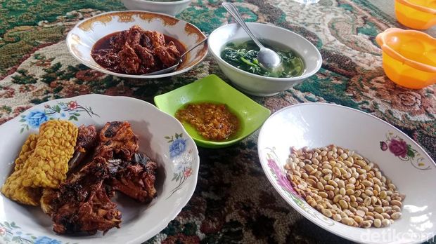Penyajian ayam rarang lengkap dengan sambal, sayuran, dan menu tambahan lain.