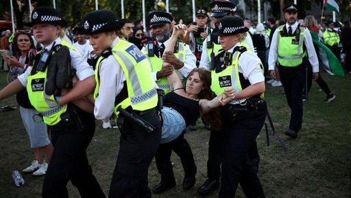 A protester is carried away by police officers at a 