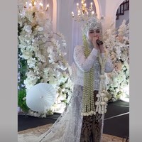Bak resepsi pernikahan, dekorasi tampak serasi dengan dihiasi bunga-bunga berwarna putih. Melly juga turut bernyanyi dan menyumbangkan suara merdunya untuk menghibur para tamu undangan. Foto: Instagram/@melly_goeslaw