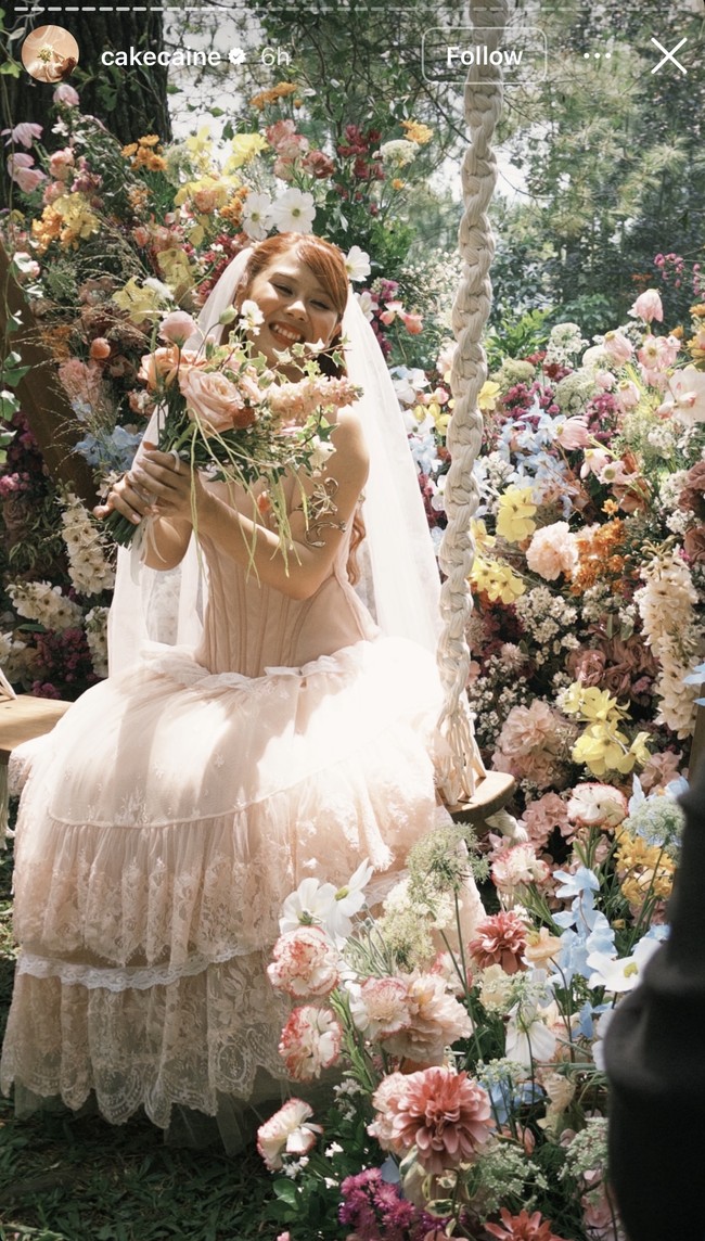 Nadin tampil cantik kenakan gaun pengantin berwarna blush pink dengan desain unik bergaya vintage-romantis. Bagian atas berbentuk korset tanpa lengan, menonjolkan siluet pinggang dan memberi kesan anggun. Foto: Instagram/@cakecaine