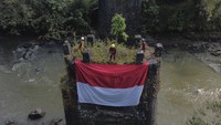 Anggota Forum Komunitas Pecinta Alam Tasikmalaya (FKPAT) membentangkan bendera merah putih saat acara Temu Akrab Pecinta Alam (TAPA) di Jembatan Perjuangan Karang Resik, Kota Tasikmalaya, Jawa Barat, Minggu (10/8/2025). ANTARA FOTO/ADENG BUSTOMI