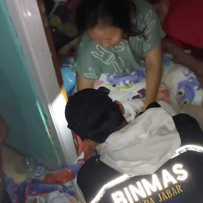 Polisi membantu mengevakuasi warga Rancabungur, Bogor yang digigit ular saat banjir menerjang rumahnya. (dok.Istimewa)