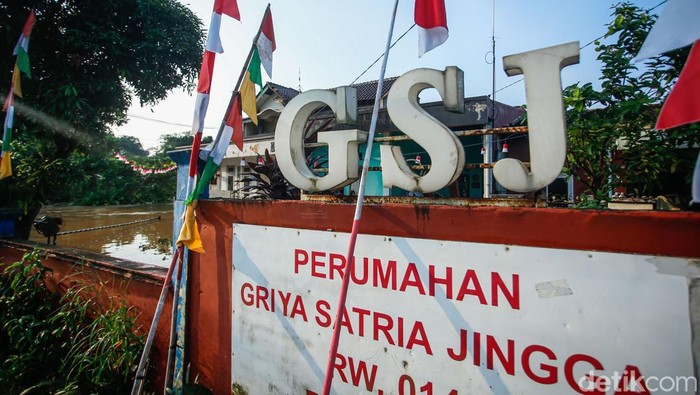Potret Banjir di Bojong Gede Warga beraktivitas di Perumahan Griya Satria Jingga, Bojong Gede, Kabupaten Bogor, Minggu (10/8/2025).Β Hujan deras sejak Sabtu (9/8) sore hingga malam membuat aliran kali di samping perumahan meluap.