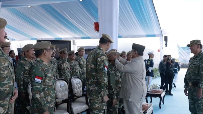 Presiden Prabowo merapikan baret Menko PM Muhaimin Iskandar (Cak Imin) di Upacara Gelar Pasukan Operasional dan Kehormatan Militer di Batujajar, Bandung. (dok Tim Media Presiden)