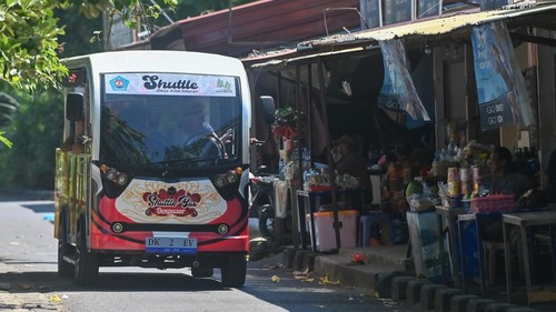 Wisatawan menaiki shuttle bus listrik di kawasan Sanur, Denpasar, Bali, Senin (11/8/2025). Pemkot Denpasar melakukan uji coba operasional shuttle bus bertenaga listrik bagi warga dan wisatawan untuk mengurangi kemacetan kawasan wisata dan mendukung Sanur sebagai wilayah rendah emisi. ANTARA FOTO/Fikri Yusuf