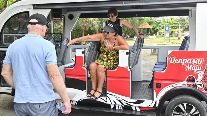 Wisatawan menaiki shuttle bus listrik di kawasan Sanur, Denpasar, Bali, Senin (11/8/2025). Pemkot Denpasar melakukan uji coba operasional shuttle bus bertenaga listrik bagi warga dan wisatawan untuk mengurangi kemacetan kawasan wisata dan mendukung Sanur sebagai wilayah rendah emisi. ANTARA FOTO/Fikri Yusuf