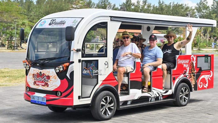 Wisatawan menaiki shuttle bus listrik di kawasan Sanur, Denpasar, Bali, Senin (11/8/2025). Pemkot Denpasar melakukan uji coba operasional shuttle bus bertenaga listrik bagi warga dan wisatawan untuk mengurangi kemacetan kawasan wisata dan mendukung Sanur sebagai wilayah rendah emisi. ANTARA FOTO/Fikri Yusuf