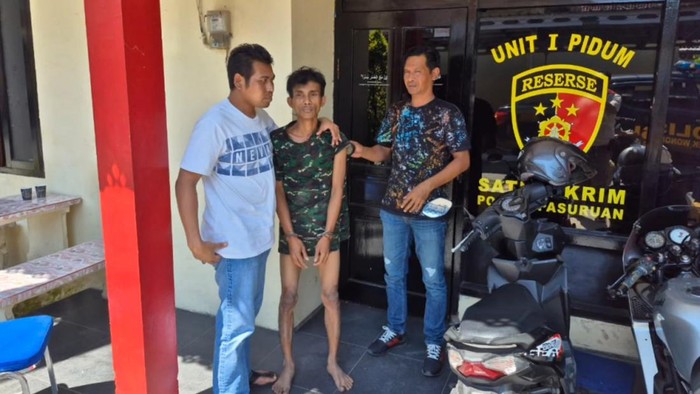 M Afandi (tengah), pelaku pembunuhan bocah tetangganya di Desa Sambisirah, Kecamatan Wonorejo, Kabupaten Pasuruan
