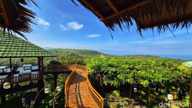 Pemandangan utama Bukit Durian Sagara Deretan meja berpayung hijau dan bangunan kayu bergaya villa berdiri di puncak bukit, menghadap langsung ke Teluk Palabuhanratu, dikelilingi bunga bougenville yang bermekaran.