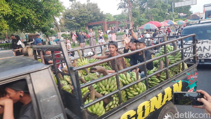 Warga memberikan donasi ratusan tandan pisang kepada aliansi masyarakat Pati bersatu di Alun-alun Pati, Senin (11/8/2025).