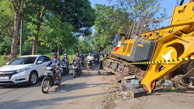 Situasi arus lalu lintas usai satu unit truk bermuatan alat berat oleng dan menimpa rumah warga di Gombel Lama, Kota Semarang, Senin (11/8/2025).