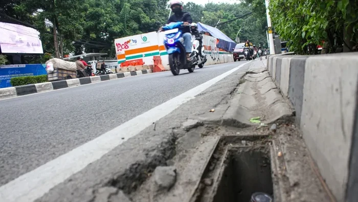 Kendaraan melintas di samping lubang drainase yang besi penutupnya hilang di Jalan Layang Pramuka-Matraman, Jakarta, Sabtu (10/5/2025)