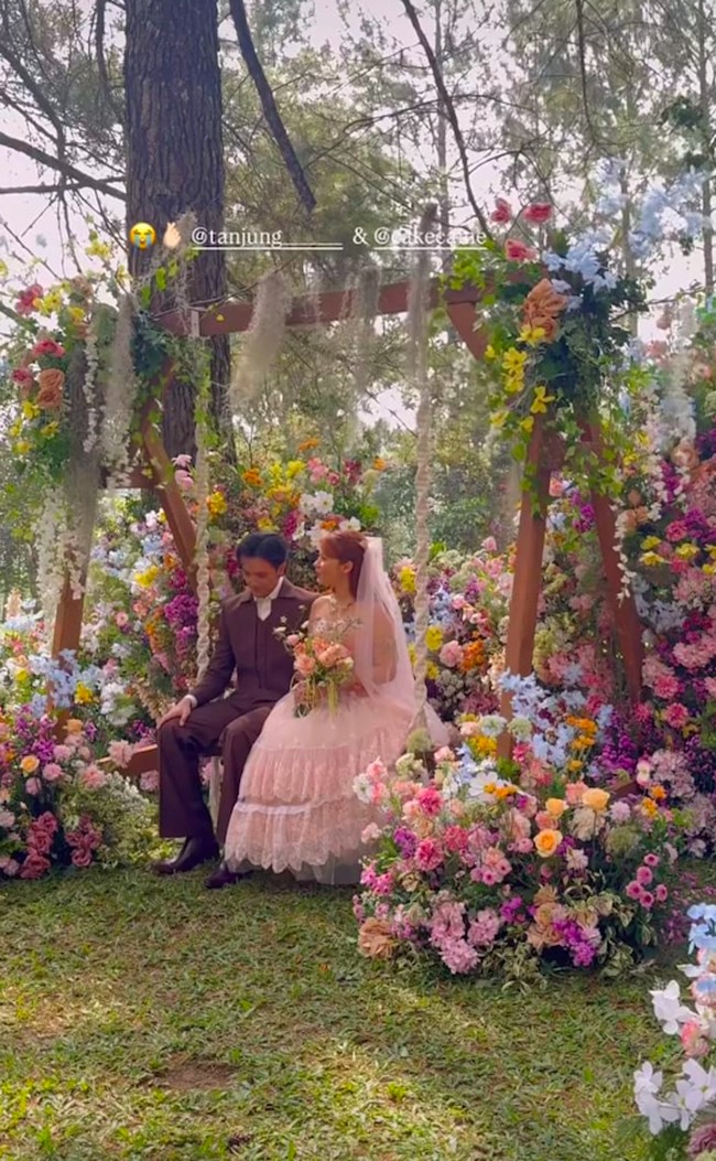Di acara resepsi pernikahannya, Nadin Amizah dan Faishal Tanjung memilih dekorasi bak negeri dongeng. Digelar outdoor pada 8 Agustus 2025, lokasi acara yang berada di tengah hutan pinus itu dihiasi dengan bungan warna-warni. Foto: Instagram @cakecaine