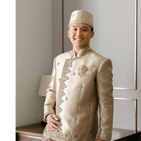 Auditya, sang mempelai pria, mengenakan beskap krem gading yang memancarkan kemewahan klasik. Potongan tegasnya diperkaya bordir emas di tepian, dengan motif tabur floral geometris yang harmonis. Foto: Instagram/@fcbweddings