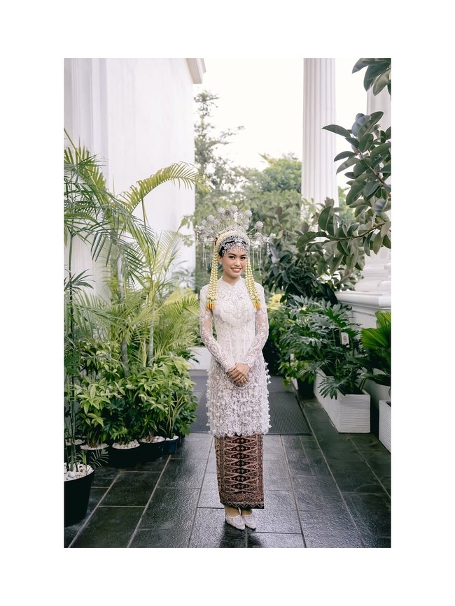 Kebaya pengantin memadukan keanggunan tradisi dengan sentuhan modern. Bagian pinggang hingga ujung kebaya ditaburi detail tassel halus, menambah dimensi gerak setiap langkahnya. Foto: Instagram/@fcbweddings