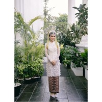 Kebaya pengantin memadukan keanggunan tradisi dengan sentuhan modern. Bagian pinggang hingga ujung kebaya ditaburi detail tassel halus, menambah dimensi gerak setiap langkahnya. Foto: Instagram/@fcbweddings