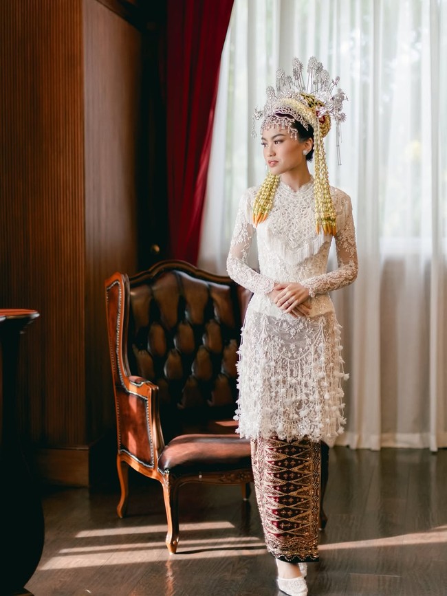 Nadira mengenakan kebaya putih dari koleksi Svarna by IKAT Indonesia karya desainer Didiet Maulana. Kebaya tampak cantik dengan hiasan bordir dan payet. Foto: Instagram/@fcbweddings