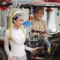 Kebaya panjang menyatu anggun dengan kain batik Betawi bermotif geometris dalam palet merah, hitam, dan emas. Foto: Instagram/@fcbweddings