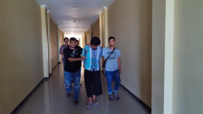 Polisi menggiring pelaku penganiayaan wanita di Pangandaran.