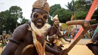 Topeng-topeng kayu hasil karya pengrajin lokal dipamerkan dalam pawai budaya, merepresentasikan roh leluhur dan kekayaan tradisi Afrika Barat. Foto: REUTERS/Charles Placide Tossou