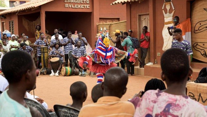 Topeng dan Tarian Satukan Afrika Barat dalam Festival Budaya Spektakuler A participant wearing a Zaouli mask from Ivory Coast, and other drummers perform during the second edition of the Benin Mask Festival, in Porto-Novo, Benin, August 3, 2025. REUTERS/Charles Placide Tossou